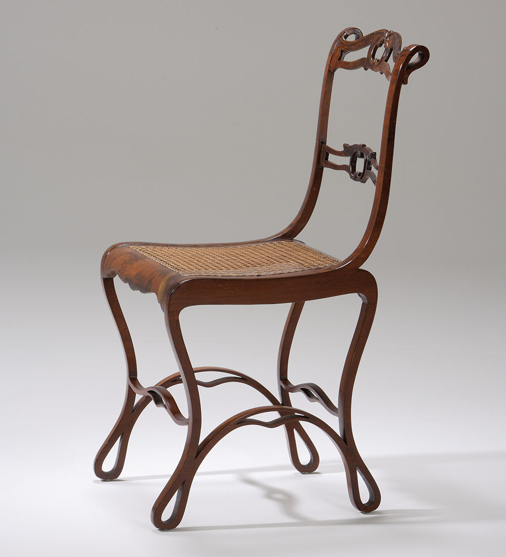 一张boppard椅子的照片，它的腿非常弯曲，椅背很细。